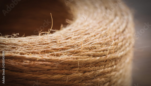 A coiled rope becomes a sandy horizon, where fibers whisper like wind over dunes