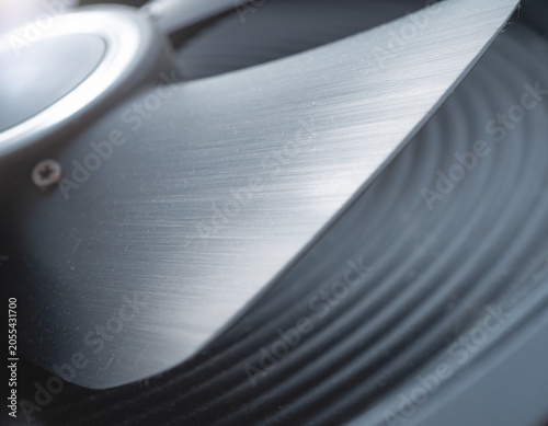 A steel blade skims a black spiral, like a quiet prophecy etched in motion