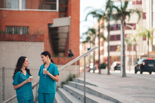 Foto Healthcare workers taking a moment to relax and chat outside the hospital premis