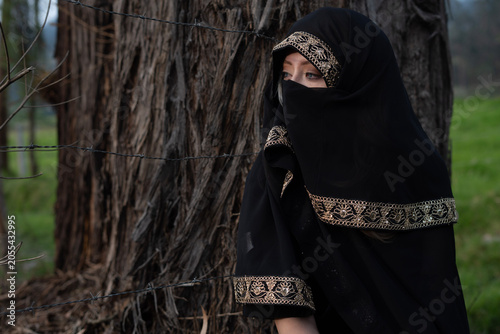 Fotografía Woman wearing niqab with barbed wire fence