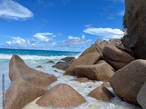 The beautiful Grand Ance Beach on La Digue Island in the Seychelles. Turquoise sea, waves, huge cliffs, white sand