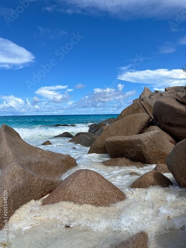 The beautiful Grand Ance Beach on La Digue Island in the Seychelles. Turquoise sea, waves, huge cliffs, white sand