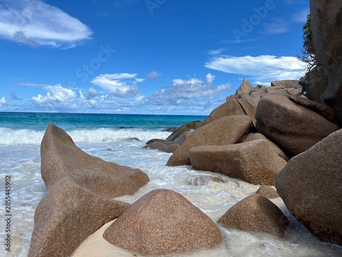 The beautiful Grand Ance Beach on La Digue Island in the Seychelles. Turquoise sea, waves, huge cliffs, white sand
