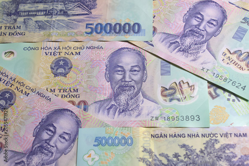 Vietnamese banknotes of 500 thousand dong (VND) with portrait of Ho Chi Minh laying on the table surface. Close-up view.