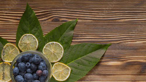 Valokuva Top view of glass jar with blueberries surrounded by dried lemon slices and gree