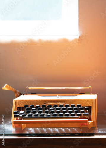 Vintage manual typewriter on a wooden desk with bright window light