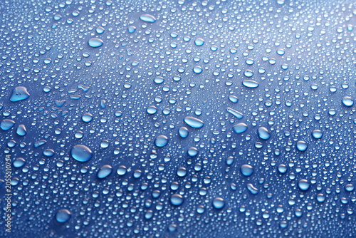 Water drops on glass on blue background