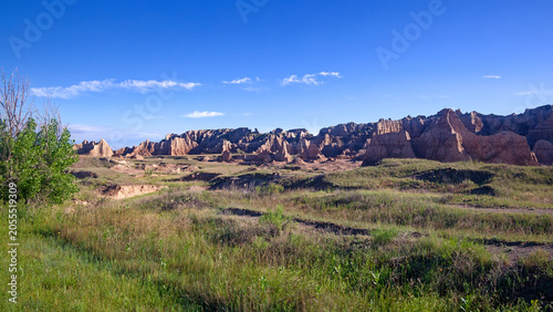 Canvas-taulu Expansive view of rugged badlands formations under a clear blue sky