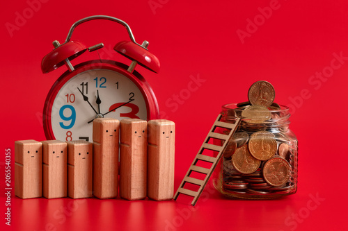 фотографія US coins in a glass jar and a line of symbolic wooden people on a red background