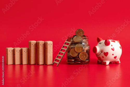Canvastavla US coins in a glass jar and a line of symbolic wooden people on a red background