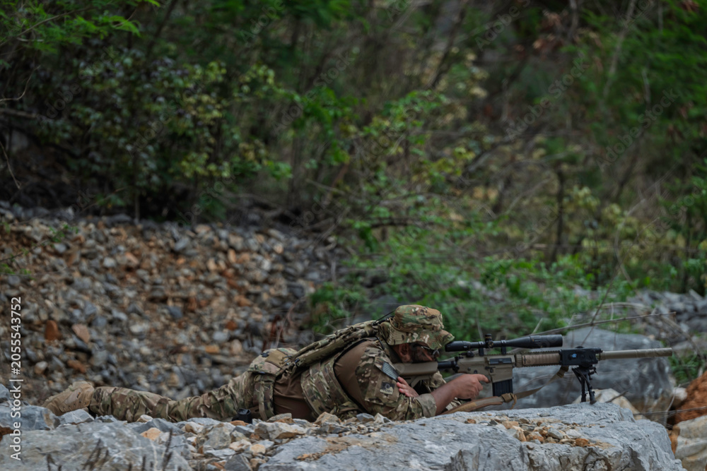 Obraz premium Military soldier signaling during a tactical field operation in rugged terrain, demonstrating battlefield communication, team coordination, mission execution, situational awareness