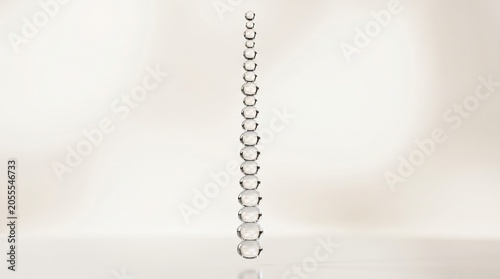 vertical stack of transparent glass spheres in a minimalist arrangement on a clean background