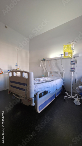 Empty hospital bed in clean patient recovery room