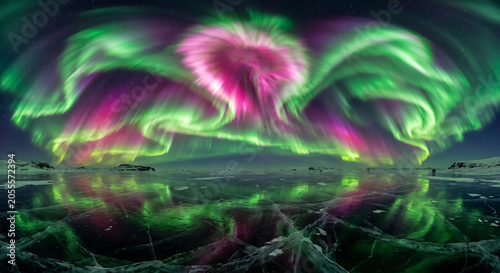 Vibrant pink and green northern lights reflecting over a cracked frozen ice field