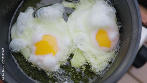Konstfotografi Two poached eggs simmering in hot water inside a cooking pot, a close-up view of preparing a simple and nutritious protein-rich breakfast at home