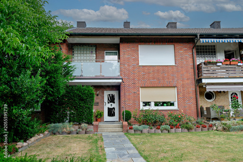 Valokuva Typical European terraced residential buildings with brick exterior, neat front lawn and flower beds