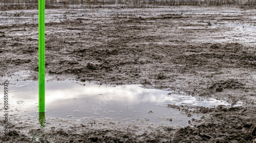 Coastal wetland restoration mud flat sediment stake wet mud overcast sky reflection low angle shot silt wetland ecosystem restoration coastal plain marsh coastal wetland restoration site with