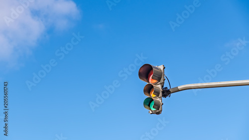 Foto Traffic light with green signal lit up against a clear blue sky with a cloud