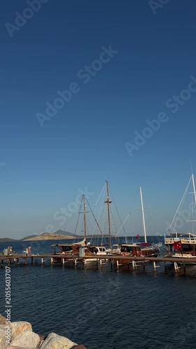 Boats and yachts floating on calm blue water under a clear sky. Scenic coastal view with peaceful sea, summer atmosphere, maritime travel, and leisure activities in a beautiful seaside destination.