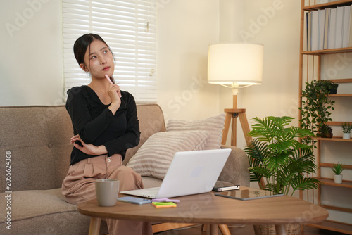 Woman Thinking While Working Remotely on Laptop