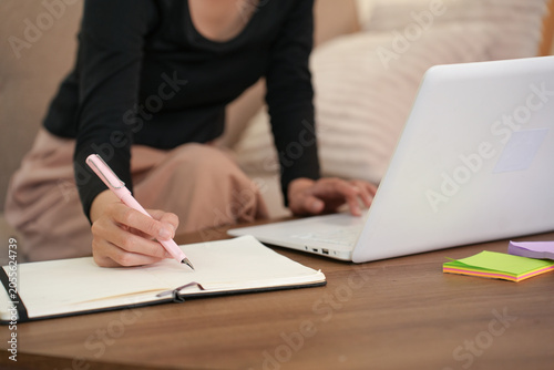 Close Up Writing Notes Next to Laptop