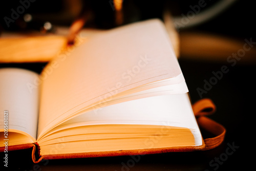 Φωτογραφία Unfurled notebook reveals blank pages illuminated by soft light indoors
