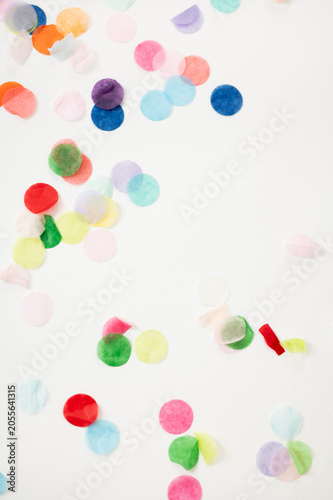Foto Colorful paper confetti scattered across a bright white background, creating a festive and playful composition