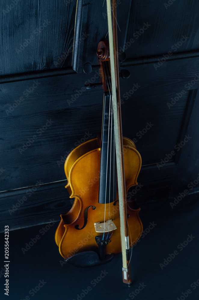 Fototapeta premium Violin in Soft Light: Red and Wood Instruments on Black Background.