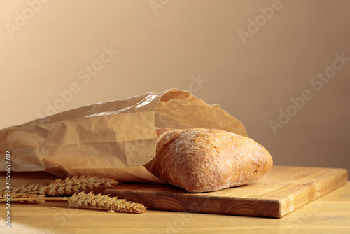 Bild auf Leinwand Fresh backed ciabatta bread in paper bag on a wooden table.