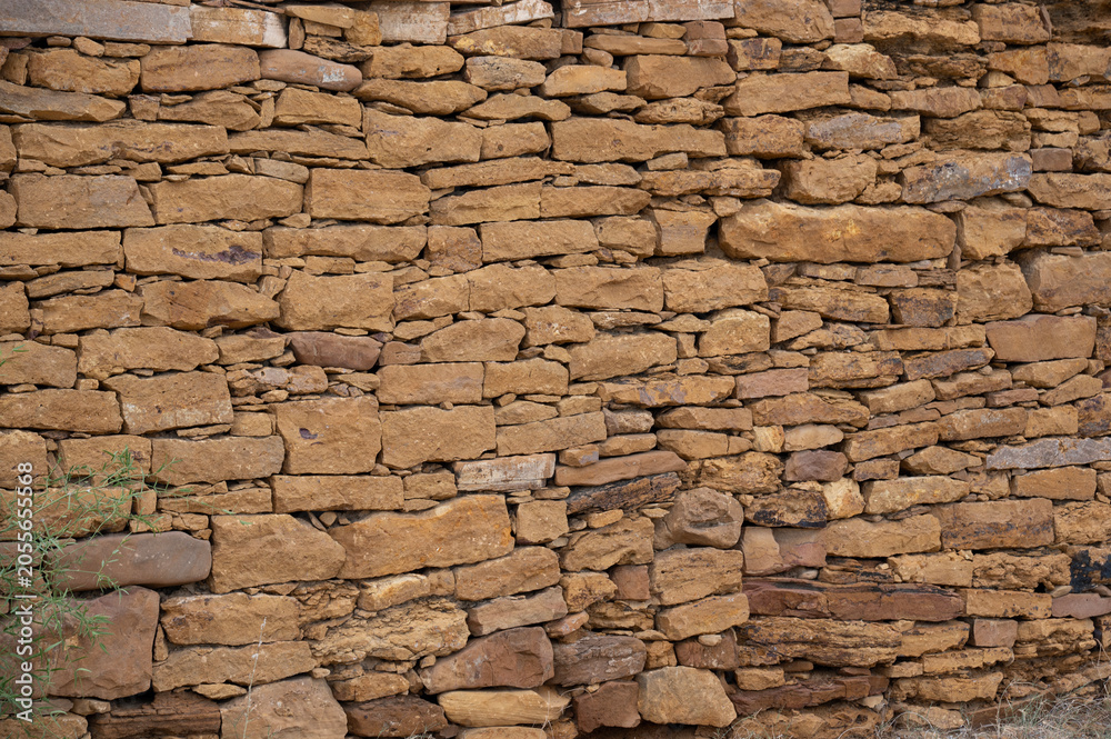 Obraz premium Close-up view of a yellow limestone wall in Jaisalmer, Rajasthan, showcasing natural stone textures, warm golden tones, and the distinctive architectural character of the historic Golden City.