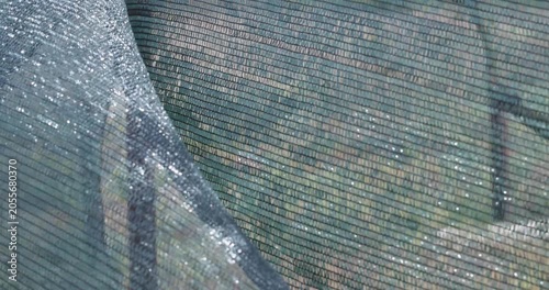 Protective shade netting waving in the wind at a construction site