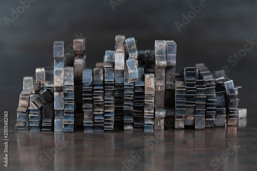 Oxidized nonferrous metal sheet components covered with natural patina and arranged in an abstract stack on a metal surface, metallurgy, recycling and industrial material processing