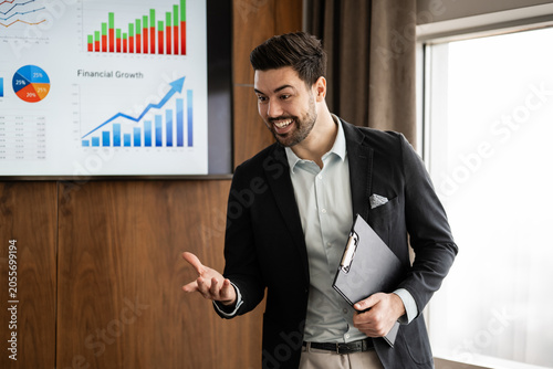 Photos Business speaker presenting financial growth data during a corporate meeting