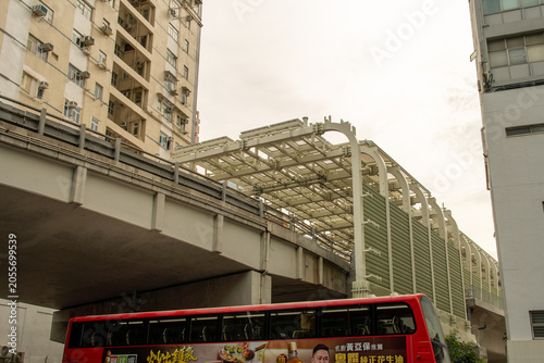 Quadro su tela Urban elevated railway infrastructure with residential buildings and red bus und