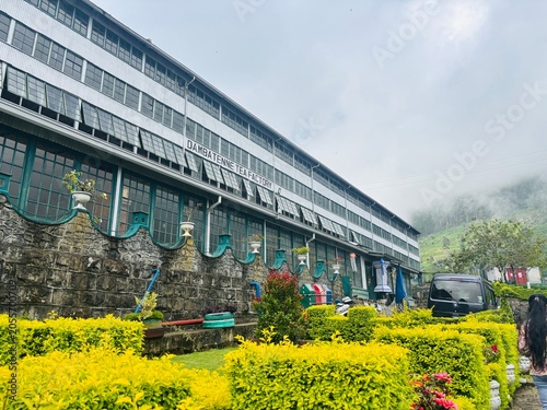 Large Building with Stone Wall and Colorful Garden in Foggy Mountainside