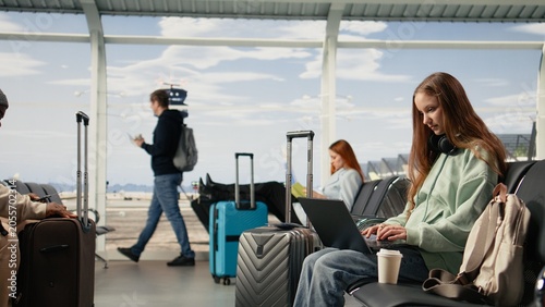 Foto Young woman practicing nomadic lifestyle and working online from the airport terminal, work anywhere and travel lifestyle concept, Flexible career