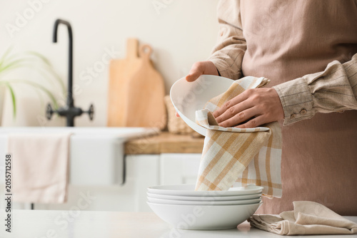 Woman in apron drying clean...