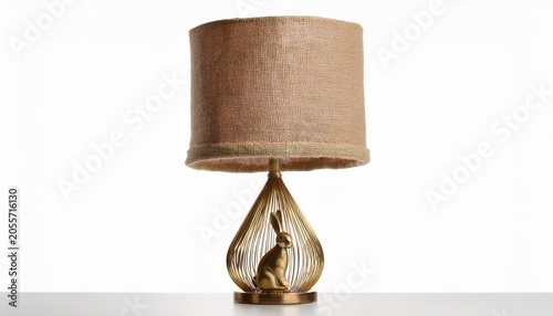 brass table lamp with sculptural rabbit base and beige burlap shade isolated on white background for interior decor use