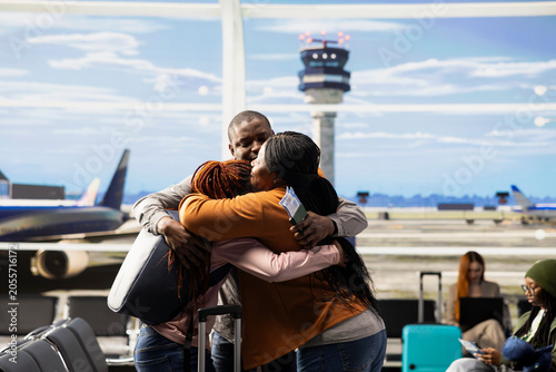 Obraz na płótnie Foreign student, waving goodbye to tearful parents, emotional moment in airport, solo traveler leaving sad but proud mother and father to study abroad, International flight departure