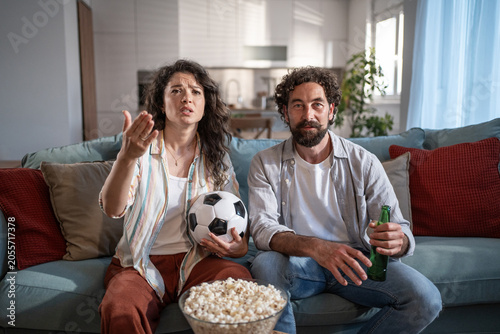 Obraz na płótnie Couple watching intense soccer game at home