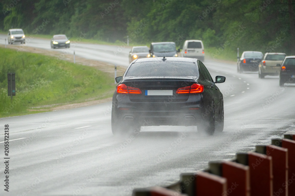 Obraz premium Heavy Traffic on Curved Highway During Rainstorm with Reduced Visibility and Wet Road Conditions