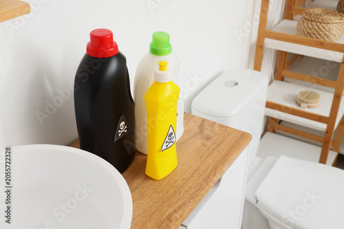 Foto Household cleaning products with skull and crossbones warning labels in a modern