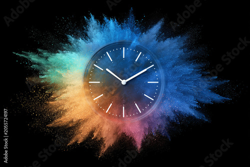 Clock with an explosion of colored powder on a black background