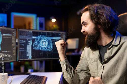 Photos Joyous software developer celebrating after awakening sentient AI capable of human level of intelligence, IT professional delighted to interact with self aware sentient artificial intelligence