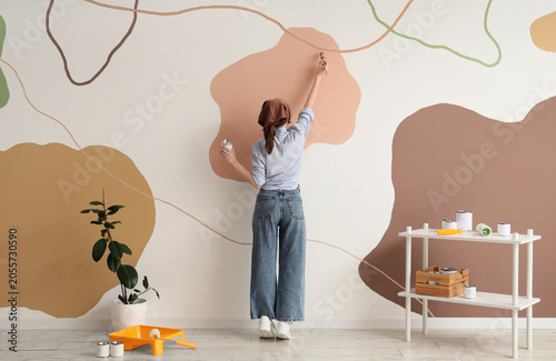 Young woman painting abstra...