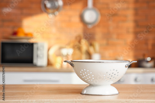 Obraz na plátně White metal colander on wooden kitchen countertop with blurred background, cooki