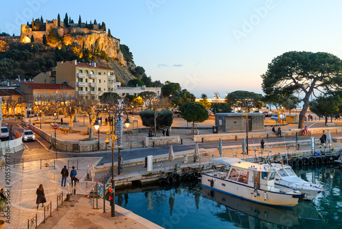 The illuminated Château de Cassis, the hilltop fortified castle, rises above the seaside town of Cassis, France, along the Mediterranean Sea at the Cote d'Azur French Riviera.