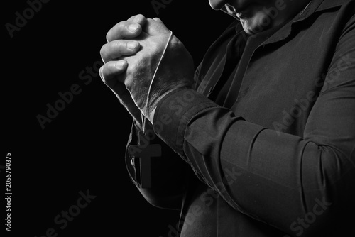 Man in black shirt praying ...