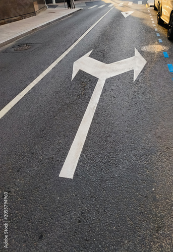 Double arrow sign showing left or right on the asphalt road on the city street. Idea choice business concept. Target line showing way in future