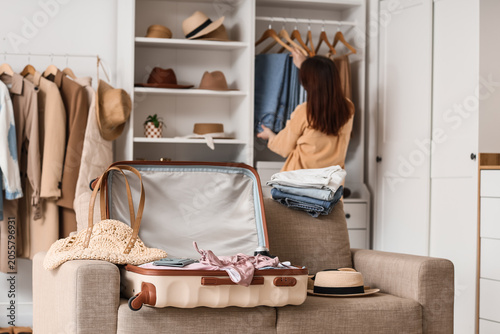 Young woman packing clothes...